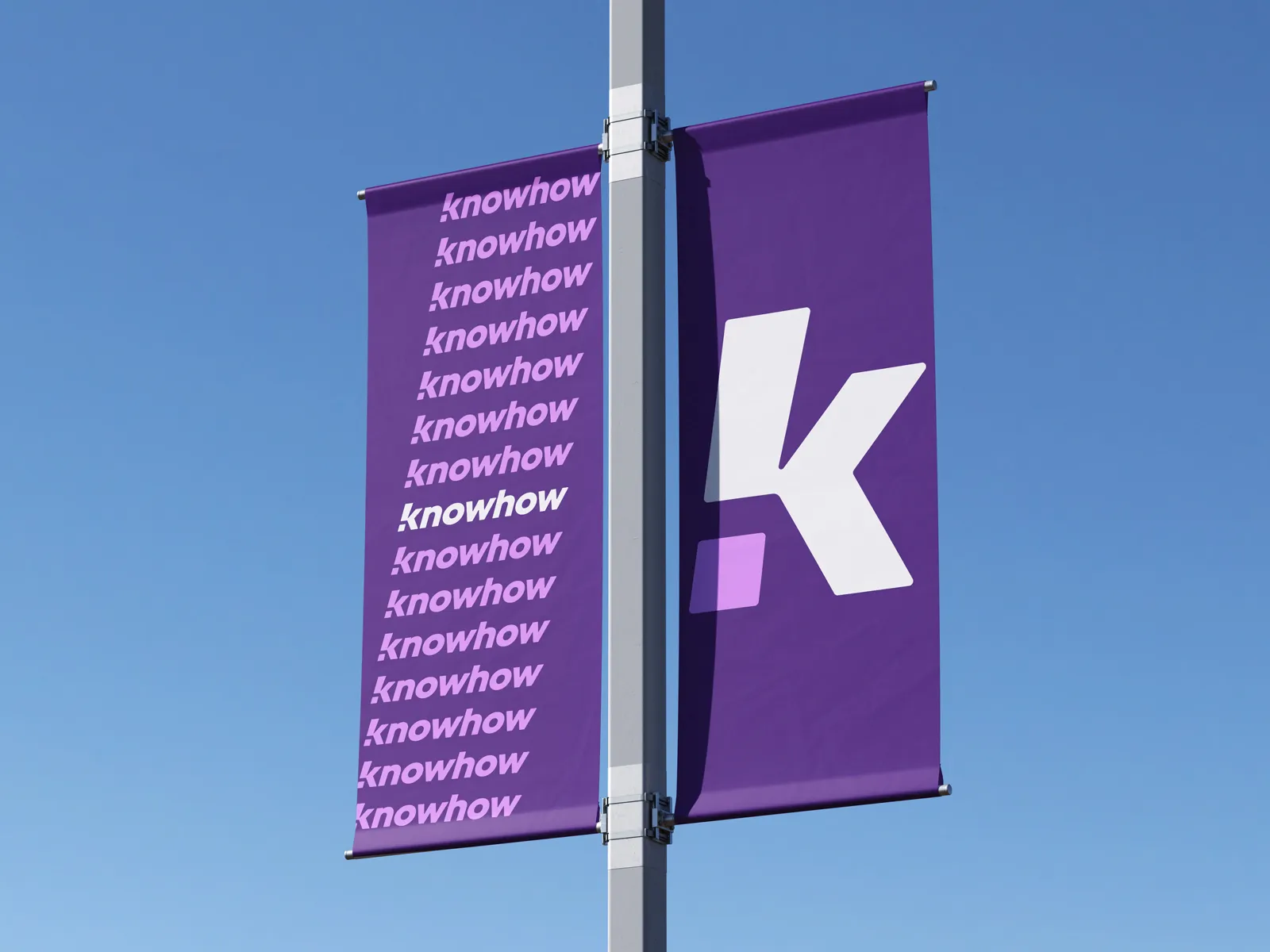 Zwei vertikale Banner von knowhow an einem Mast – links mit wiederholtem Claim, rechts mit großem ‚K‘-Logo auf violettem Hintergrund.